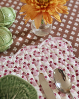 Trudie Constance Chocolate Round Tablecloth with Ruffle close up view of a table setting with placemat and napkins