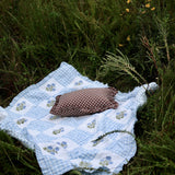 Trudie Dorothy Blue Embroidered Quilted Throw Blanket styled with throw pillow